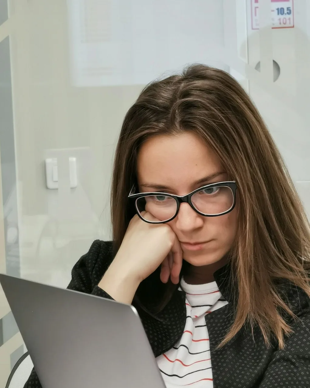Nachdenkliche Managerin blickt ratlos auf ihren Laptop
